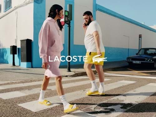 Lacoste young woman and man crossing a road
